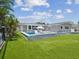 An exterior view of the backyard featuring a pool, lounge chairs and artificial turf at 5512 Tropic Dr, New Port Richey, FL 34653