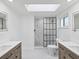 Bright bathroom with dual vanities, a skylight, and a modern glass-enclosed shower at 5512 Tropic Dr, New Port Richey, FL 34653