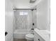 Modern bathroom featuring sleek gray tiles, bathtub with shower, contemporary fixtures, and a clean aesthetic at 5512 Tropic Dr, New Port Richey, FL 34653