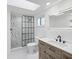 Modern bathroom with a glass-enclosed shower featuring unique tilework and an elegant vanity at 5512 Tropic Dr, New Port Richey, FL 34653
