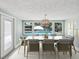 Dining room with large windows providing pool views, seating for eight and statement lighting at 5512 Tropic Dr, New Port Richey, FL 34653
