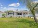 Charming single-Gathering home featuring manicured landscaping, an American flag, and a welcoming entrance at 5512 Tropic Dr, New Port Richey, FL 34653