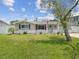 Well-kept single-story house with green lawn, tasteful landscaping, and an inviting front entrance with a light blue door at 5512 Tropic Dr, New Port Richey, FL 34653