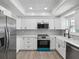 Bright kitchen with white cabinets, stainless steel appliances, mosaic backsplash, and ample counter space at 5512 Tropic Dr, New Port Richey, FL 34653