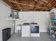 Garage laundry area with modern washer, dryer, sink, water heater and ample storage space at 5512 Tropic Dr, New Port Richey, FL 34653