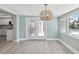 Living room with wood-look flooring, stylish light fixture, and pool views at 5512 Tropic Dr, New Port Richey, FL 34653