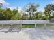 A view from the backyard deck to the fenced yard, mature trees, and landscaping at 6076 Shiprock Ave, Spring Hill, FL 34608