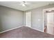 Spacious carpeted bedroom with ceiling fan and entry to hallway at 6076 Shiprock Ave, Spring Hill, FL 34608