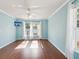 Bedroom boasts hardwood floors, a ceiling fan, light blue walls, and two windows with natural light at 6076 Shiprock Ave, Spring Hill, FL 34608