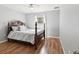 Bedroom featuring light blue walls, hardwood floors, and a bed with a dark wooden frame at 6076 Shiprock Ave, Spring Hill, FL 34608