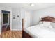 Bedroom features light blue walls, hardwood floors, and a bed with a dark wooden frame and white bedspread at 6076 Shiprock Ave, Spring Hill, FL 34608