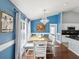 Dining room featuring stylish lighting, blue walls with white trim, and view to the kitchen at 6076 Shiprock Ave, Spring Hill, FL 34608