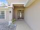 Inviting front porch with a decorative front door and manicured landscaping at 6076 Shiprock Ave, Spring Hill, FL 34608