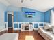 Cozy living room with a fireplace, blue walls, and plenty of natural light at 6076 Shiprock Ave, Spring Hill, FL 34608