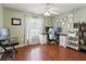 Home office featuring hardwood floors, light green walls, ceiling fan, and natural light from the window at 6076 Shiprock Ave, Spring Hill, FL 34608