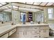 Bathroom with double sinks, drawers, cabinets, and framed mirror above a long counter at 6340 Spoonbill Dr, New Port Richey, FL 34652