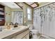 Bathroom with toilet, vanity, framed mirror, shower and decorative shower curtain at 6340 Spoonbill Dr, New Port Richey, FL 34652