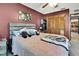 Bedroom with a bed, ceiling fan, dark maroon colored walls and wooden closet doors at 6340 Spoonbill Dr, New Port Richey, FL 34652