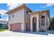 Two-story stucco house with a brown garage door and a covered front entry with stairs at 6340 Spoonbill Dr, New Port Richey, FL 34652