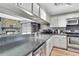 Efficient kitchen with stainless steel appliances and an open view into the living room featuring a stone fireplace at 6340 Spoonbill Dr, New Port Richey, FL 34652