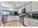 Well-lit kitchen with stainless steel appliances, lots of cabinet space, and an open view into the living room at 6340 Spoonbill Dr, New Port Richey, FL 34652