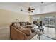 Living room with a large sectional couch, tile floors, and glass sliding doors leading to the pool at 6340 Spoonbill Dr, New Port Richey, FL 34652