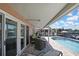 Poolside lounge seating under covered patio providing shade and relaxation with canal views in a private backyard at 6340 Spoonbill Dr, New Port Richey, FL 34652