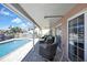Inviting pool deck with covered seating area and a view of the canal, perfect for outdoor entertaining at 6340 Spoonbill Dr, New Port Richey, FL 34652