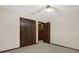 Neutral bedroom with dark wood trim, and bi-fold closet doors and a ceiling fan at 642 Erin Way, Brooksville, FL 34601