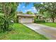 Home showcasing a two-car garage, well-kept lawn, and neatly trimmed hedges, enhancing its curb appeal at 642 Erin Way, Brooksville, FL 34601