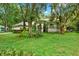 Charming home showcasing a well-manicured front yard with lush landscaping, mature trees, and inviting curb appeal at 642 Erin Way, Brooksville, FL 34601