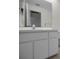 Bathroom vanity with white cabinets, large mirror, updated faucet and laminate countertop at 6425 Thicket Trl, New Port Richey, FL 34653