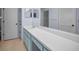 Bathroom featuring a vanity with double mirrors, ample counter space, and linen closet at 6425 Thicket Trl, New Port Richey, FL 34653