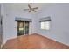 This home features a ceiling fan, sliding door, and wood-look flooring at 6425 Thicket Trl, New Port Richey, FL 34653