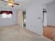 Bedroom with neutral carpet, a ceiling fan, and convenient access to an attached bathroom at 6425 Thicket Trl, New Port Richey, FL 34653