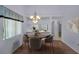 Bright dining area featuring hardwood floors and elegant chandelier lighting at 6425 Thicket Trl, New Port Richey, FL 34653