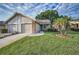 Charming single-story home featuring a manicured lawn, attached two-car garage, and a welcoming exterior at 6425 Thicket Trl, New Port Richey, FL 34653
