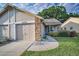 Attractive home featuring a well-kept lawn, brick detailing, and an attached garage at 6425 Thicket Trl, New Port Richey, FL 34653
