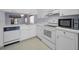 Well-lit kitchen with modern appliances, white cabinetry, and a view into the adjacent room at 6425 Thicket Trl, New Port Richey, FL 34653