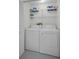 Laundry room features a washer, dryer, and storage shelves at 6425 Thicket Trl, New Port Richey, FL 34653
