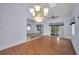 Open living room with wood floors, a modern chandelier, and access to outdoor space at 6425 Thicket Trl, New Port Richey, FL 34653