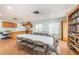 Bright recreation room with an equipped kitchen, tables, chairs, and a bookshelf for social gatherings at 6425 Thicket Trl, New Port Richey, FL 34653