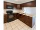 Modern kitchen with dark cabinetry, granite countertops, and stainless steel appliances at 6450 Limerick Ave, New Port Richey, FL 34653