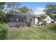 Private backyard featuring a screened-in pool and well-maintained lawn, perfect for outdoor activities and relaxation at 6490 Pine Meadows Dr, Spring Hill, FL 34606