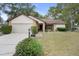 Inviting home features a two-car garage and manicured landscaping, enhancing its curb appeal at 6490 Pine Meadows Dr, Spring Hill, FL 34606