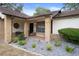 Charming covered front porch with brick columns and decorative landscaping at 6490 Pine Meadows Dr, Spring Hill, FL 34606