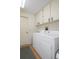 This laundry room features a white washer and dryer along with lots of cabinet storage space at 6490 Pine Meadows Dr, Spring Hill, FL 34606