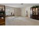 Open-concept living room with carpet, display cabinet, and an adjacent doorway at 6490 Pine Meadows Dr, Spring Hill, FL 34606