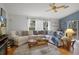 Bright living room with plush sectional sofa, blue accents, and plenty of natural light at 6490 Pine Meadows Dr, Spring Hill, FL 34606
