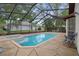 Enclosed pool with attached spa and flagstone patio at 6490 Pine Meadows Dr, Spring Hill, FL 34606